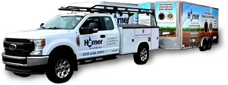 Truck and trailer with another box truck in the background with businesss wraps with Harner Plumbing on both